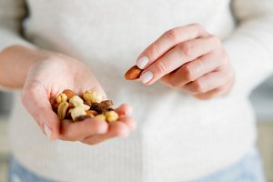 Close-up of a woman holding a handful of protein-rich nuts
